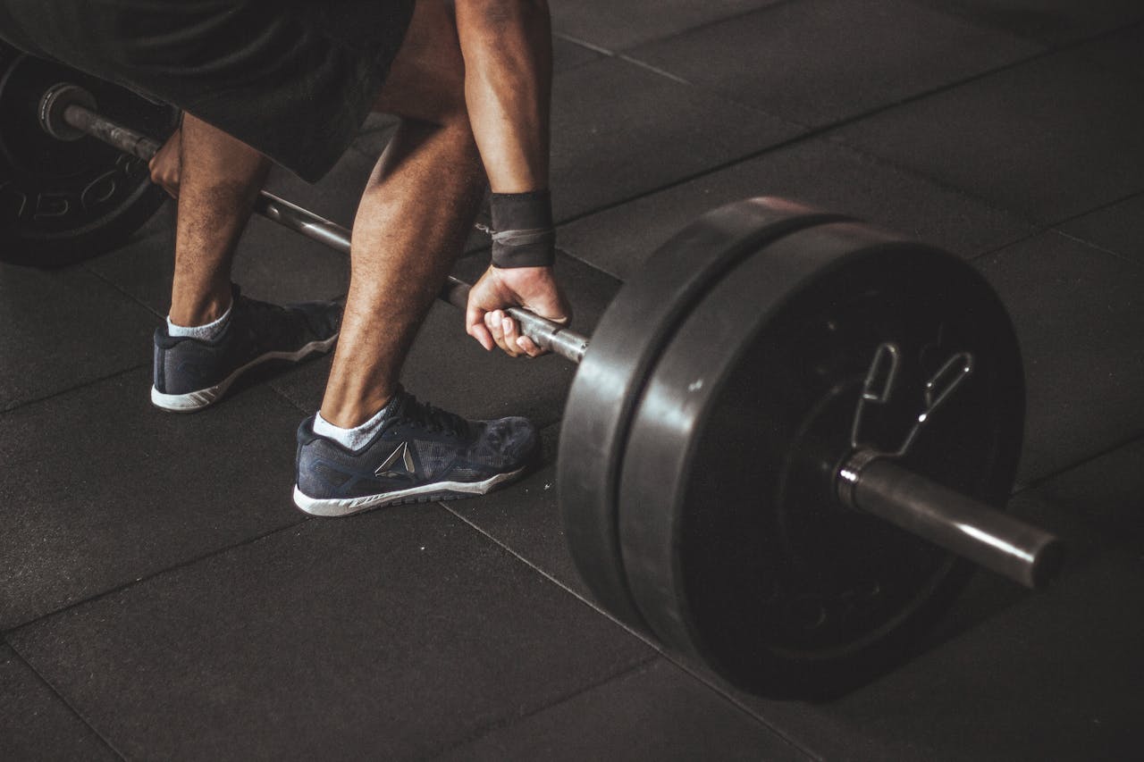 our-experience A man lifting a heavy barbell during a gym workout, showcasing strength and fitness.